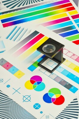 a camera sitting on top of a pile of paper Click Click Graphics - imprimerie Bruxelles Printing Brussels drukkerij Brussel